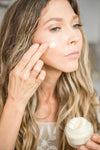 Model applying Fresh Face Cream Anti-Aging Tallow Moisturizer to her cheek, showcasing smooth application.
